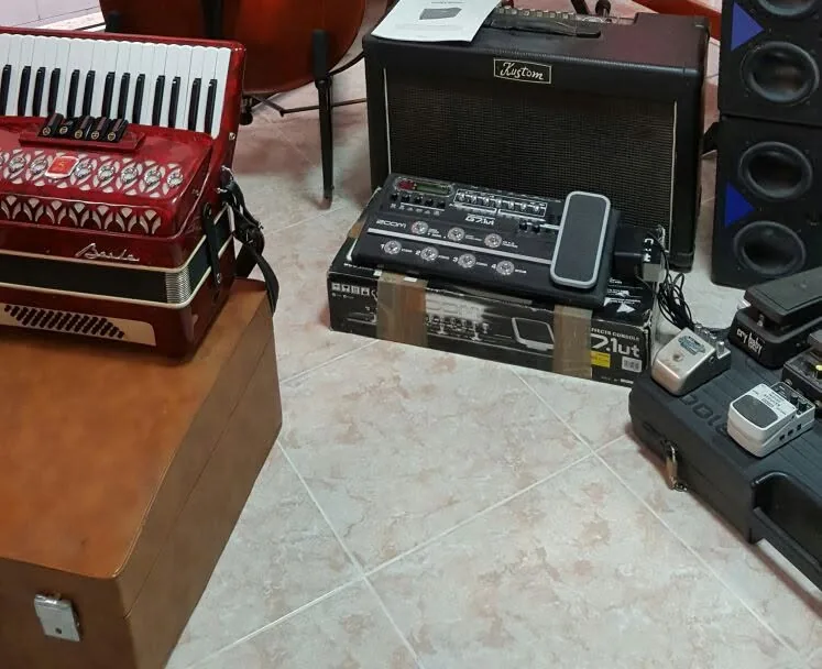 Acordeón rojo, amplificador y pedaleras de efectos